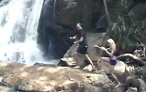 Couple rests by a waterfall